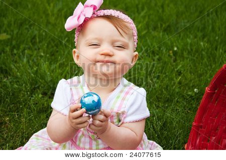 Velikonoční Baby drží vejce úšklebkem