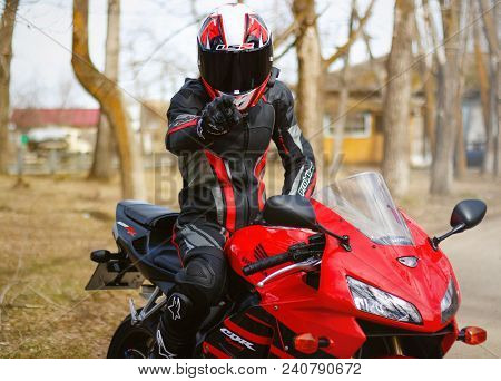 Krasnoyarsk, Russia - April 21, 2018: Beautiful Motorcyclist In Full Gear And Helmet On A Red And Bl