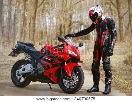 Krasnoyarsk, Russia - April 21, 2018: Beautiful Motorcyclist In Full Gear And Helmet On A Red And Bl