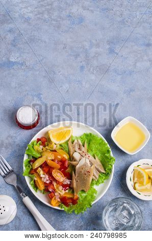 Fish Fillet With Raw Vegetables And Lemon In A Dish On The Table. Selective Focus.