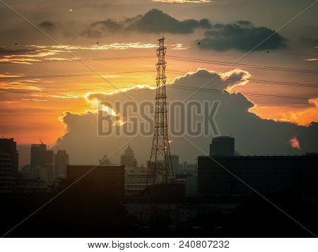 Sun Behind A Cloud At Sunset With An Industrial Skyline