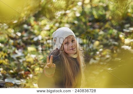 A Girl In Autumn Yellow Leaves In Sunset Rays