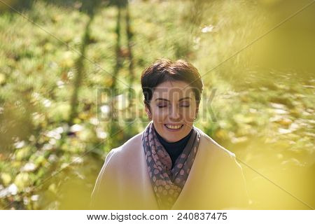 Woman In Autumn Yellow Leaves In Sunset Rays