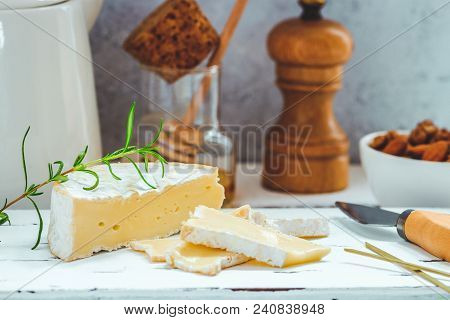 Cheese Plate Served With Crackers, Honey And Nuts. Camembert On White Wood Serving Board Over White 