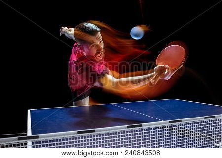 The Table Tennis Player In Motion. Fit Young Sports Man Tennis-player In Play On Black Background Wi