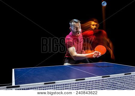 The Table Tennis Player In Motion. Fit Young Sports Man Tennis-player In Play On Black Background Wi