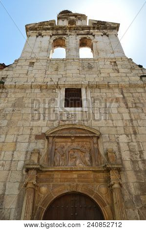 Beautiful Front Facade Of The Church Of Alcala De Henares University With A Nest Of Storks In Its Ol