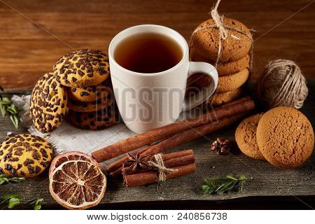 Traditional Christmas Tea Concept With A Cup Of Hot Tea, A Large Set Of Cookies On A Homespun Napkin