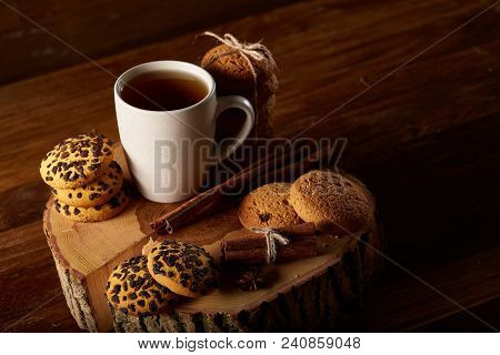 Christmas Concept With A Cup Of Hot Tea, A Large Set Of Cookies On A Homespun Napkin, Cinnamon Stick