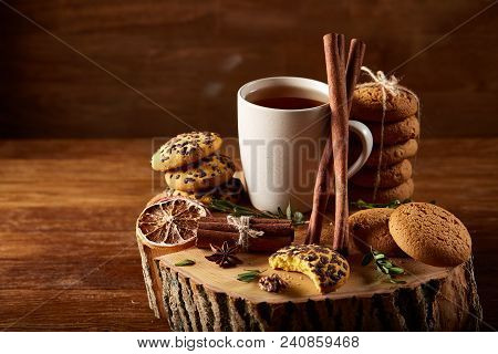 Christmas Concept With A Cup Of Hot Tea, A Large Set Of Cookies On A Homespun Napkin, Cinnamon Stick