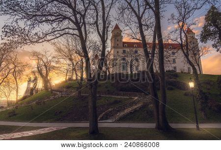Bratislava Castle Or Bratislavsky Hrad Through The Trees At Sunset. The Main Castle Of Capital City 
