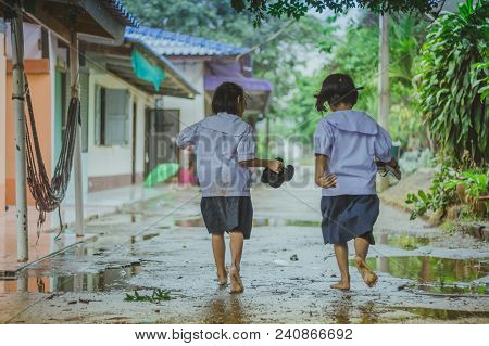 Students Walk To The Flood After Rain In School.