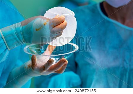 Surgeon Preparing Breast Silicone Implant For The Operation Of Breast Augmentation