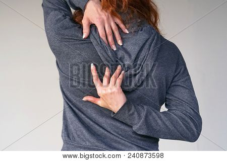 Close-up View Of A Young Woman With Pain In Kidneys Isolated On Gray Background. Young Woman With Ba