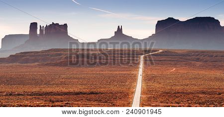 A Road In The Utah Desert With Mountain Plateaus, Buttes In The Background