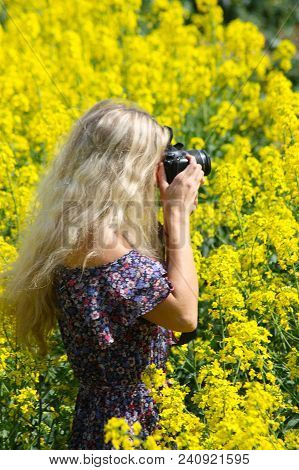 Blonde Girl On The Blooming Yellow Rapeseed Field