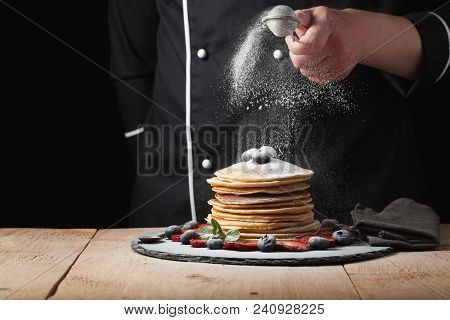 Serving Pancakes With Powdered Sugar And Berries. Chef Woman Hand. Beautiful Food Still Life. Slight