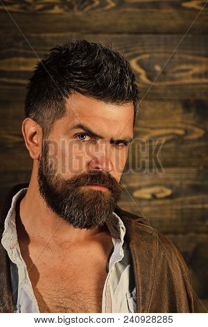Serious Hipster In Barbershop, Look. Man With Beard And Mustache On Wooden Background. Barber And Ha
