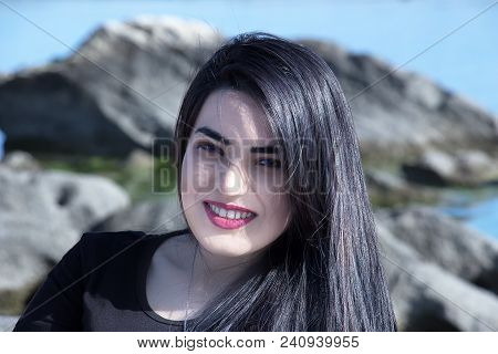 Happy Woman On The Beach. Portrait Of A Beautiful Girl Close-up. Spring Portrait On The Beach. Young