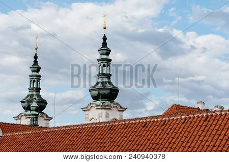 Spires And Roof Of Strahov Monastery In Prague Against Cloudy Sky. Low Angle View
