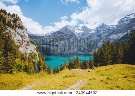 Idyllic panorama view of the azure lake Oeschinensee. Location place Swiss alps, Kandersteg, Bernese Oberland, Europe. Scenic image of most popular tourist attraction. Discover the beauty of earth.
