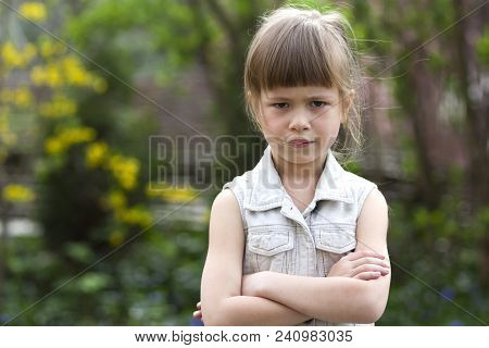 Pretty Funny Moody Little Blond Preschool Girl In White Sleeveless Dress Looks Into Camera Feeling A