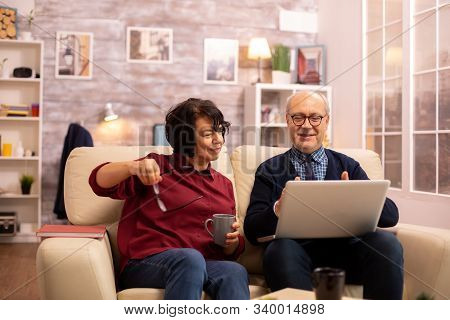 Elderly Old Couple Using Modern Laptop To Chat With Their Grandson