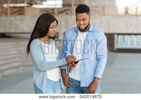 Exit Poll Concept. Female Interviewer Making Voter Survey Outdoors After Election, Talking With Youn