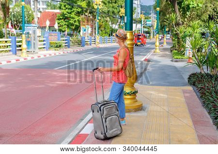 Woman Tourist Standing Near The Bus Staition With Luggage During The Vacation Trip. Travel In Asian 