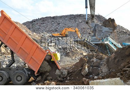 Dump Truck Unloading Of Broken Concrete Slabs Demolition Waste On Landfill. Reuse Concrete. Salvagin