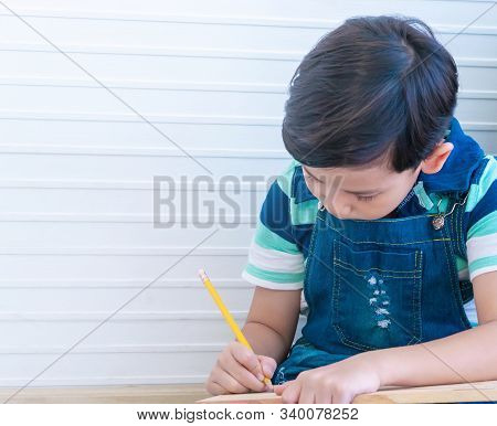Asian Boy Is Using Pencil To Wirting On Wood For Child Education Concept