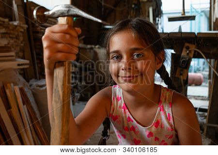 Waist Up Portrait Of The Attarctive Brunette Girl With Blue Eyes, Stands Among The Carpentry Worksho
