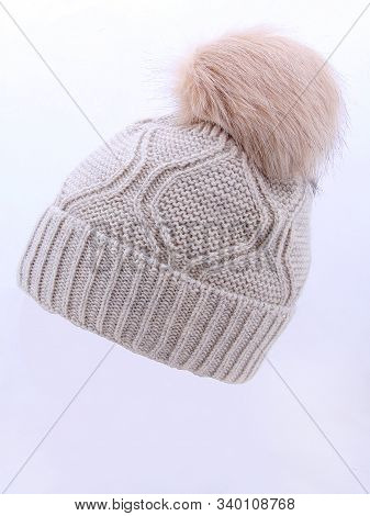Beige Wool Knit Ski Hat With Faux Fur Pompom Isolated On White. Bobble Hat Topped With Pom Pom Or Lo
