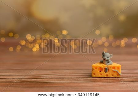 A Toy Mouse Sits In Cheese On A Wooden Starry Background, A Symbol Of 2020.
