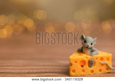 A Toy Mouse Sits In Cheese On A Wooden Starry Background, A Symbol Of 2020.