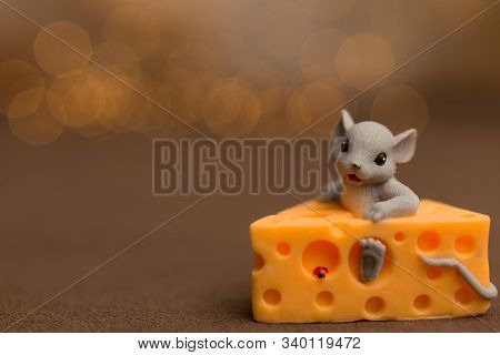A Toy Mouse Sits In Cheese On A Wooden Starry Background, A Symbol Of 2020.