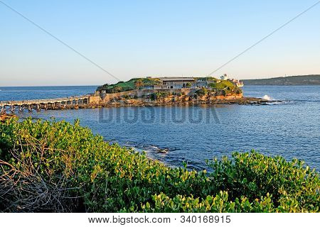 Famous Bare Island And Its Wooden Footbridge In Sunset Light, Sydney Australia. It Is A Former Milit