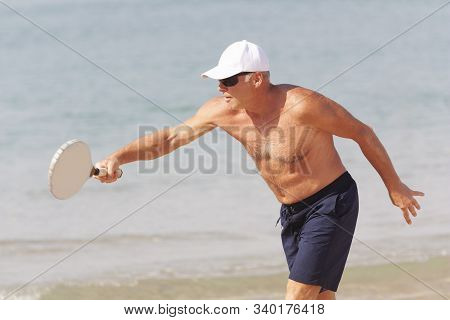 Adult Male Playing Matkot On The Beach