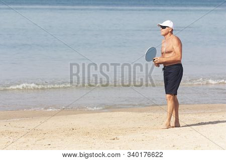 Adult Male Playing Matkot On The Beach