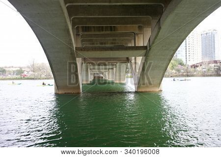 Canoes Paddeling Under The Bridge In Austin Texas In Winter