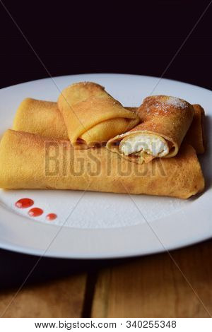 Russian pancakes on black wooden background, blini, blintchiki