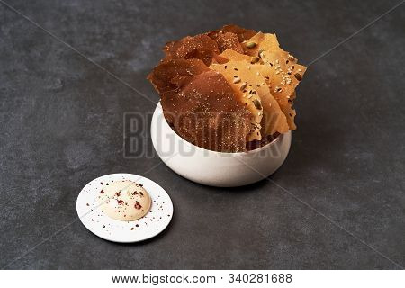 Cereal Chips With Seeds And Kimchi Mayonnaise Sauce On Dark Background