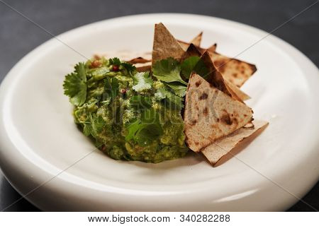 Guacamole With Pita Chips On White Plate. Chef's Signature Dish