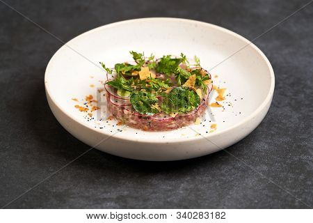 Fresh Beef Tartare Dish With Fresh Vegetables In White Plate