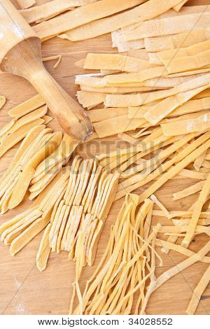 พาสต้าโฮมเมดไข่ uncooked บนกระดานตัดชนิดต่าง ๆ
