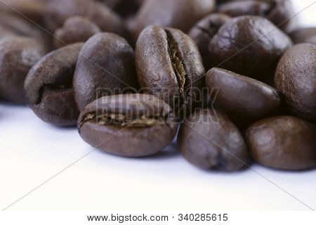 A Group Of Freshly Roasted Coffee Beans On A White Background.close-up, Horizontal, Macro, Place For