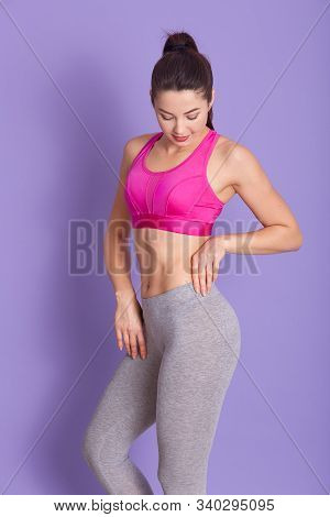 Full Length Photo Of Sporty Well Built Sportswoman Posing Isolated Over Lilac Background In Studio, 