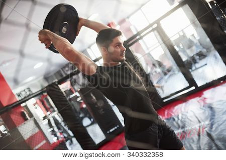 Exercise For The Strength Of Separate Muscles. Man Has Workout In The Gym. Having Exercise With Panc