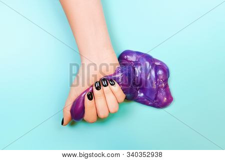 Hands With Holding Slime In Purple Color On Blue Background