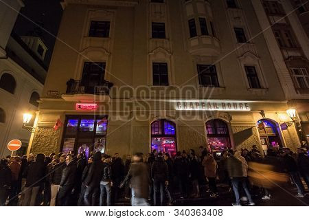 Prague, Czechia - November 1, 2019: Crowd Of People Queuing In Front Of Chapeau Rouge At Night. Chap